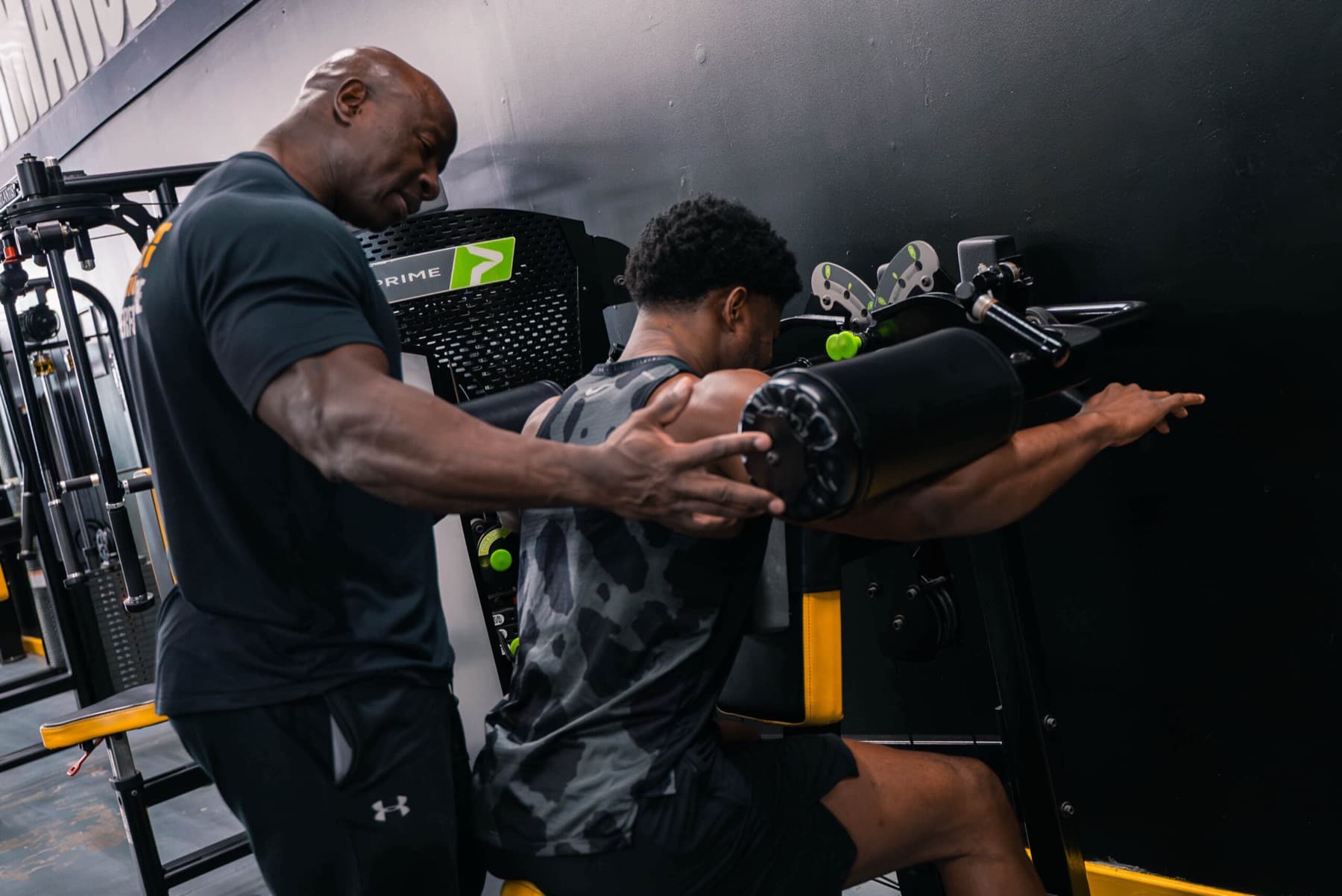 A coach guiding a client through a machine row